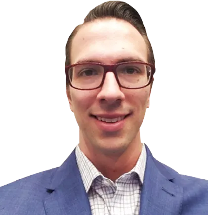 A person wearing glasses, a checkered shirt, and a blue suit jacket, smiling at the camera against a plain background, ready for an exciting Rosemont Distillery Tour.